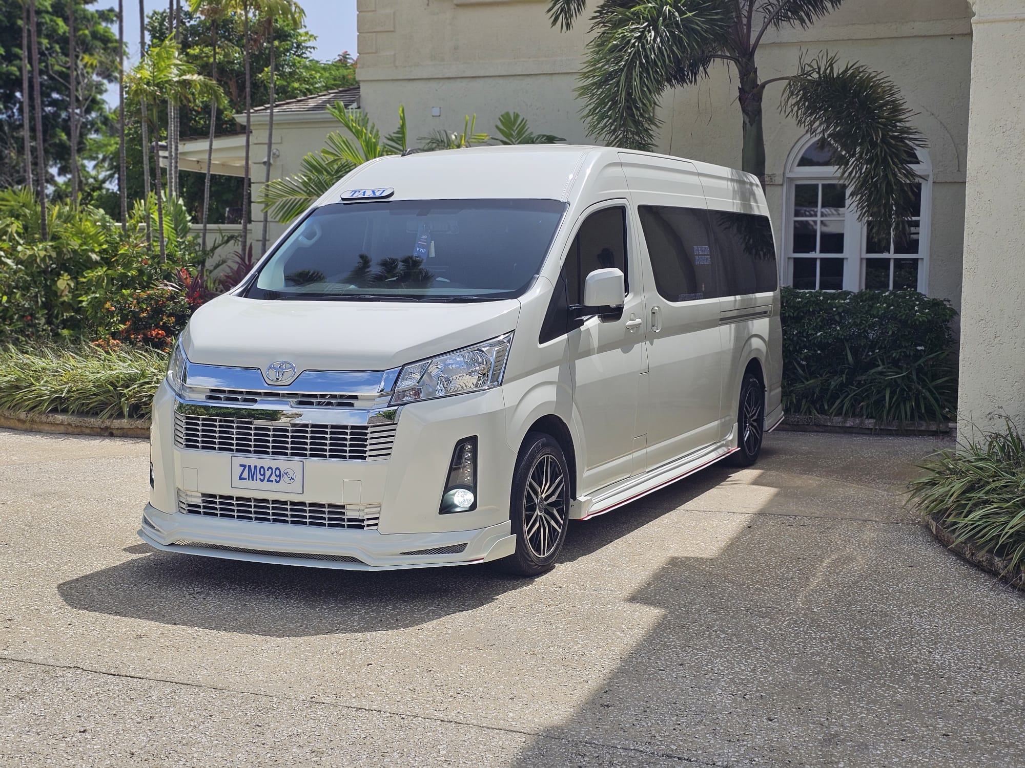 Unique Chauffeurs white luxury van collecting guests from a Barbados villa